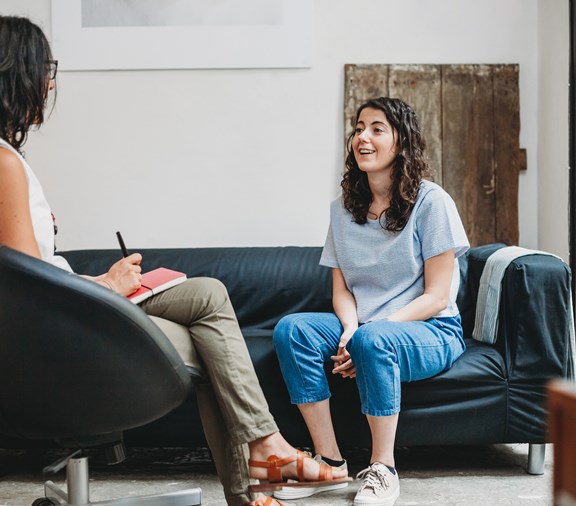 Psychotherapy session, young woman talking to her psychologist in their office about her behavioral health