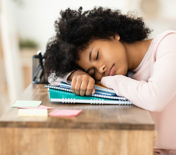 teenager sleeping at desk