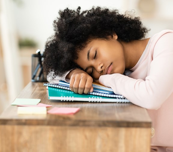 teenager sleeping at desk