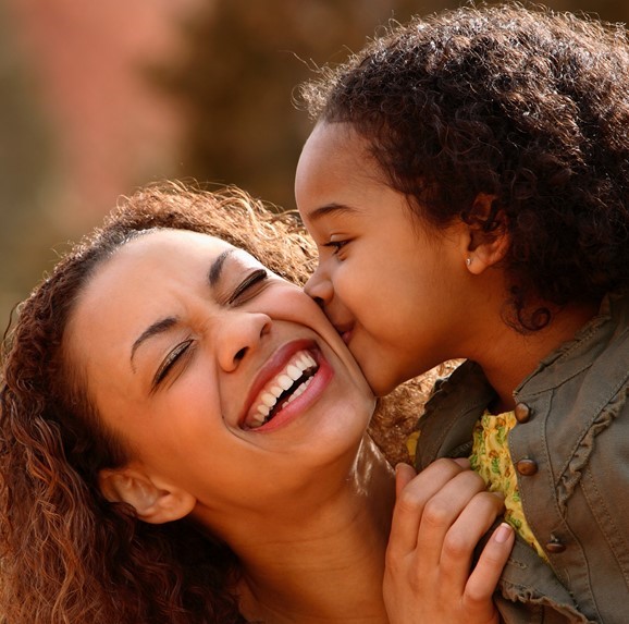 Child kissing mother on cheek