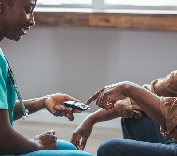 happy elderly man with nurse getting diabetes test