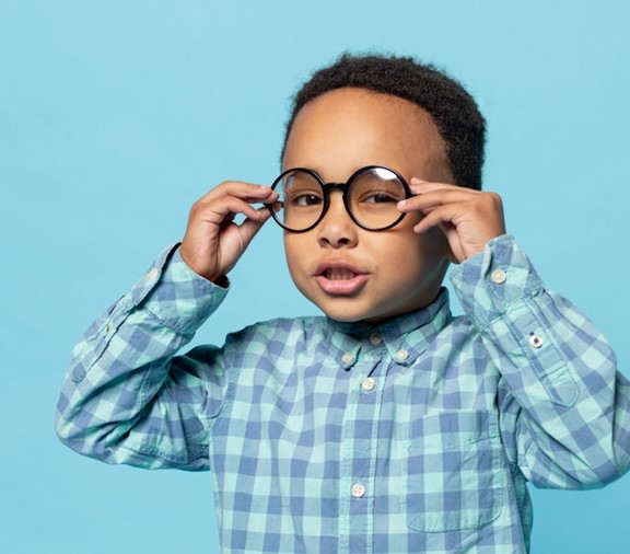 child trying to fix glasses