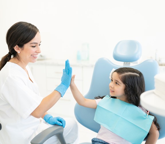 Young girl high fives her dentist 