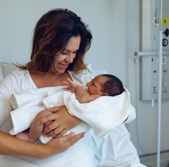 New mom holding baby in hospital bed