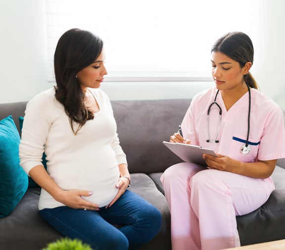 female nurse making home visit to first time pregnant expecting mother