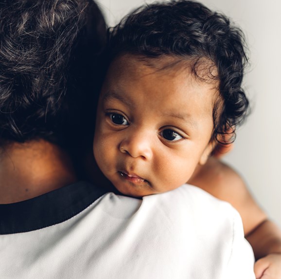 Mom holding baby looking over her shoulder